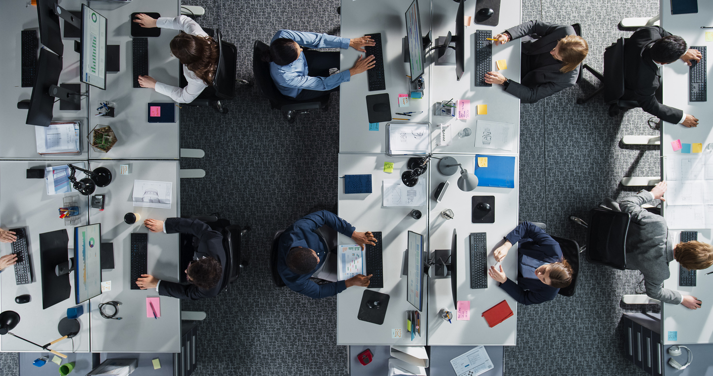 Overhead view of a team working at their desks, illustrating a Microsoft 365 digital workplace