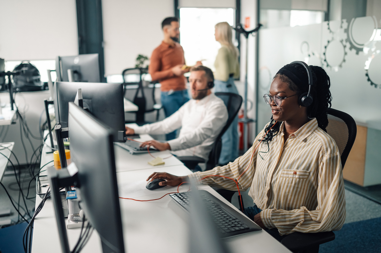 Contact center agents working at headset-equipped workstations, illustrating a contact center AI solution