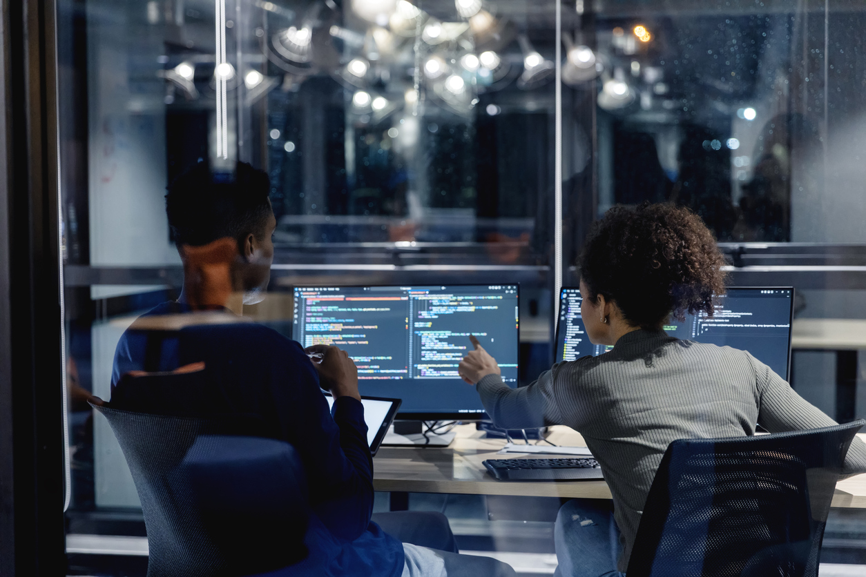 Two IT professionals collaborating at a workstation, illustrating managed IT services decisions